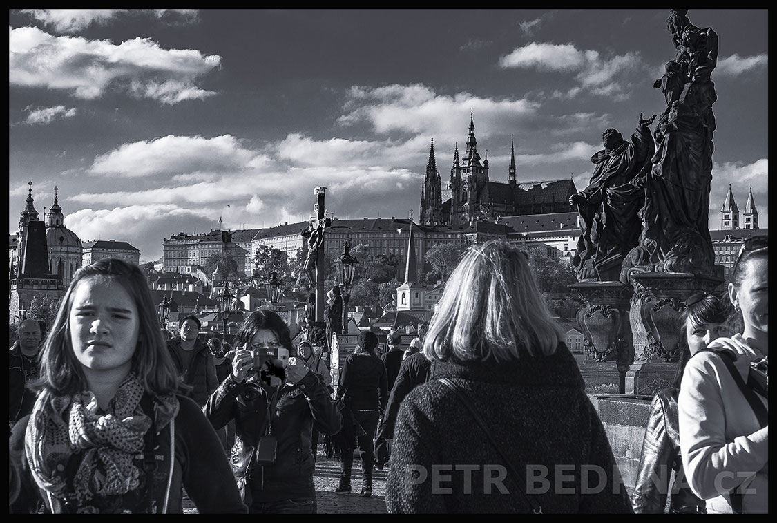 Fotografka na Karlově mostě, Mostecké věže, Pražský hrad, Praha, street foto, žena, muž, sochy, Česko