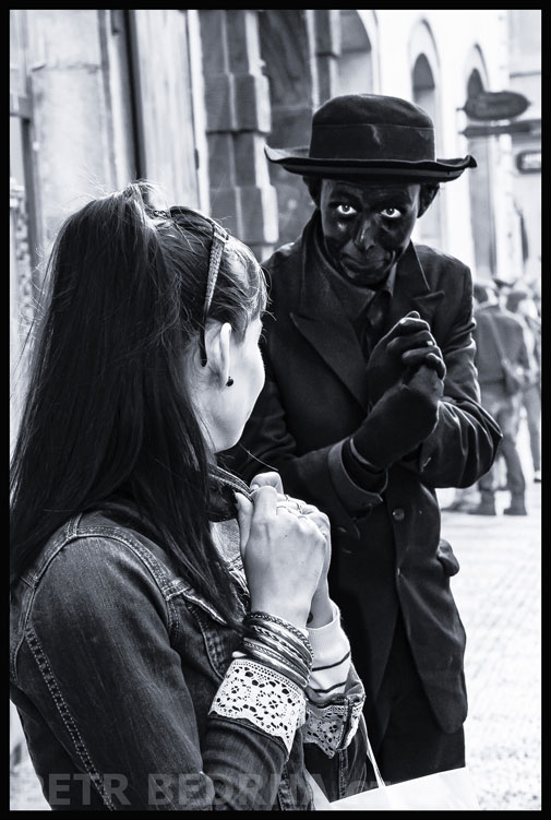 Dívka a černý mim s velkýma očima, Praha - Malá Strana, ulice Mostecká, street foto, Česko